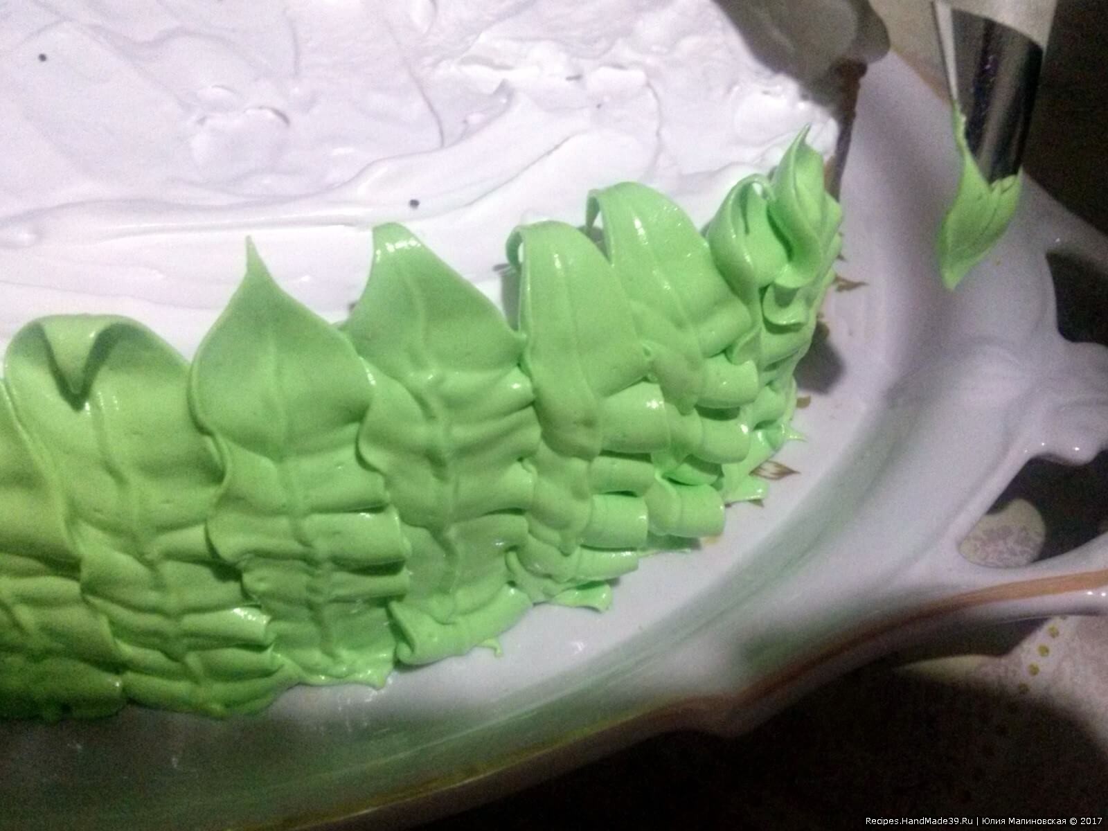Остальное безе подкрасить в зелёный цвет и выдавить через насадку «листик» на весь торец торта, имитируя водоросли