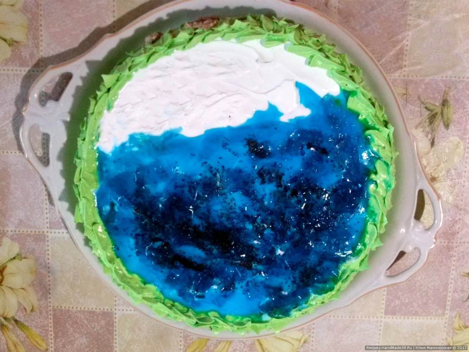 Желе приготовить по инструкции, окрасить голубым красителем. Когда желе начнёт застывать, выложить его на большую половину торта