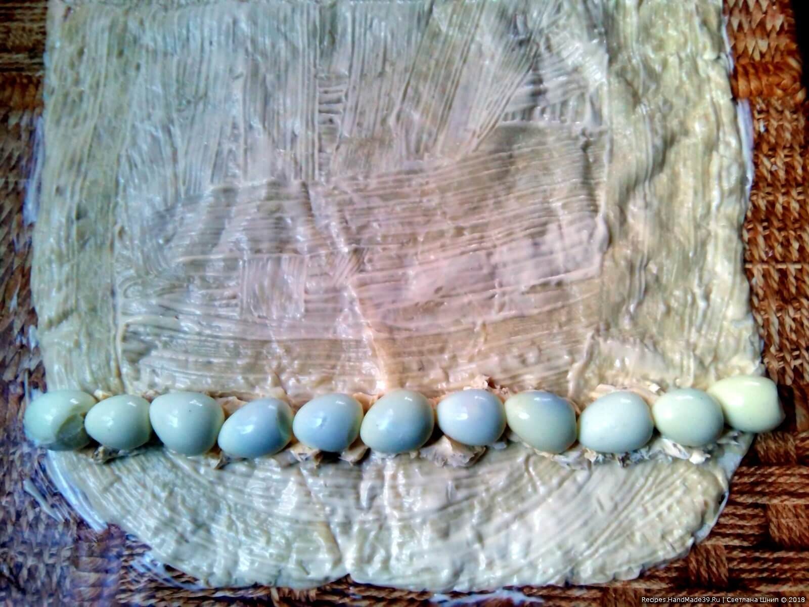 Сверху на полоску выложить один к одному перепелиные яйца