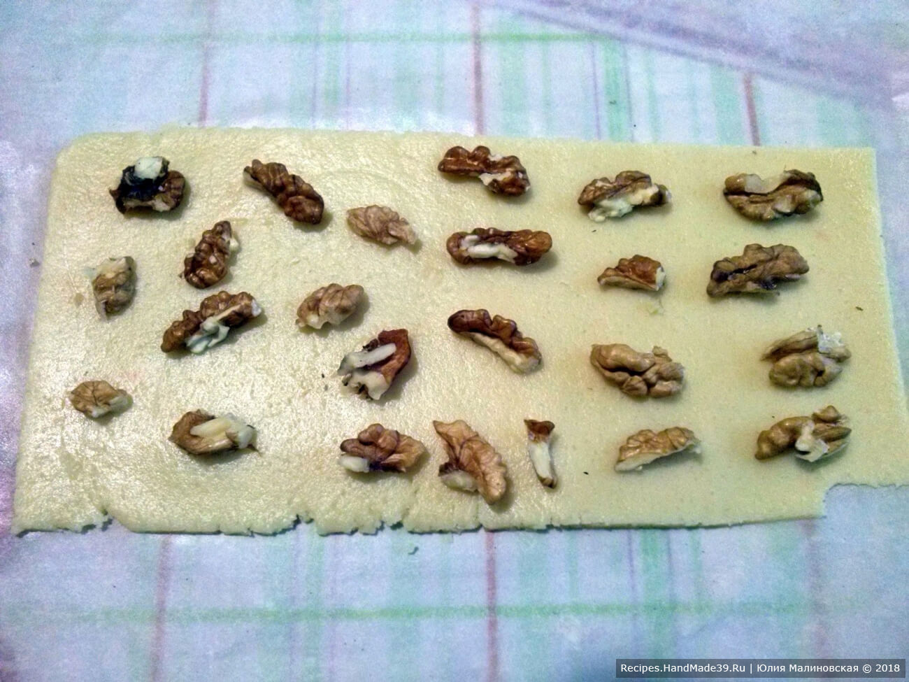 На полосу из белого теста выложить орехи