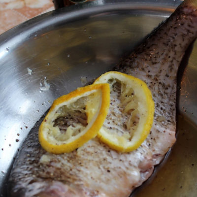 Рыбу натереть солью, специями внутри и снаружи, добавить соевый соус и 1 столовую ложку лимонного сока