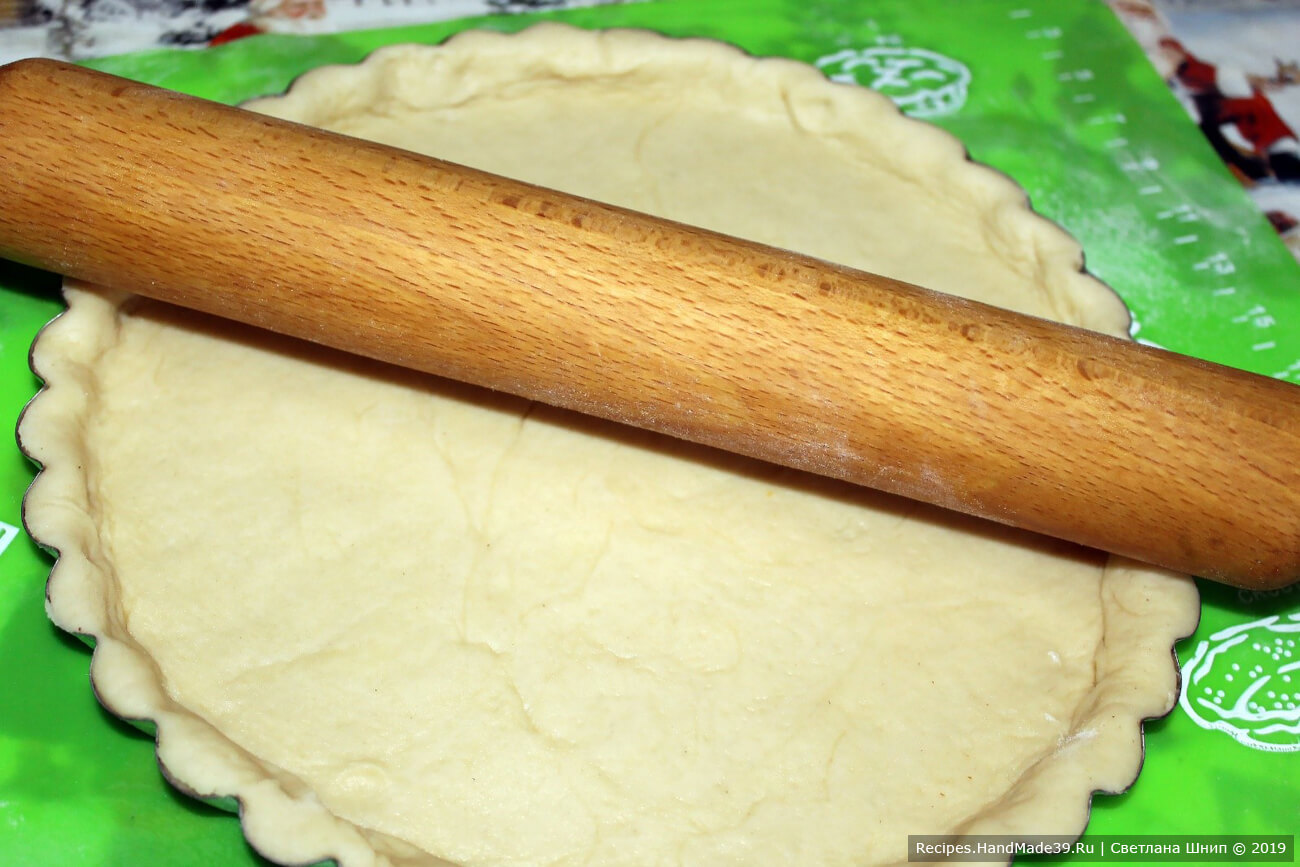Выложить тесто в форму, сделать высокие бортики. Смазать бортики взбитым желтком