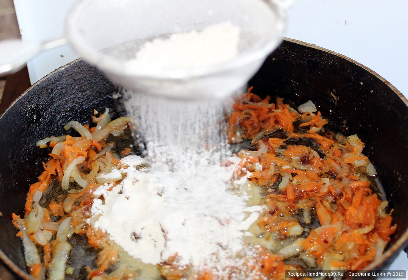 Добавить к обжаренным овощам лавровый лист, перец горошком и 1 столовую ложку муки