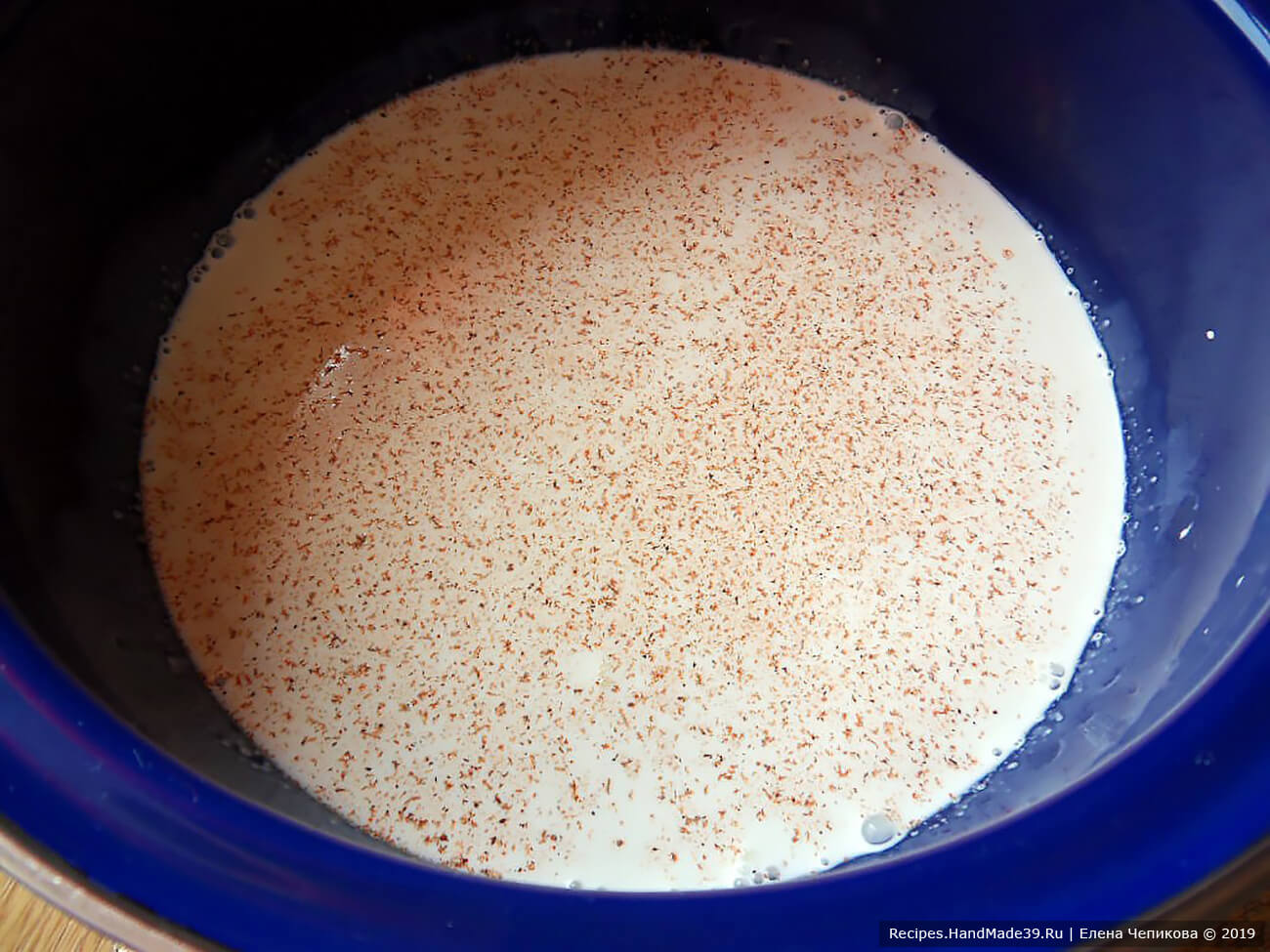 В кастрюле нагреть нежирные сливки, добавить соль и молотый сладкий перец