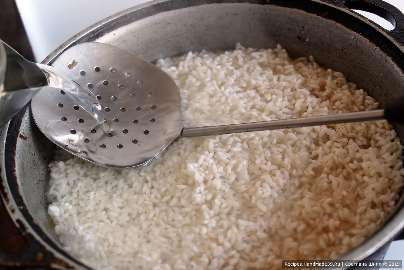 Сверху выложить рис, залить кипятком на 1-1,5 см выше риса. Накрыть крышкой и варить до полного выпаривания воды
