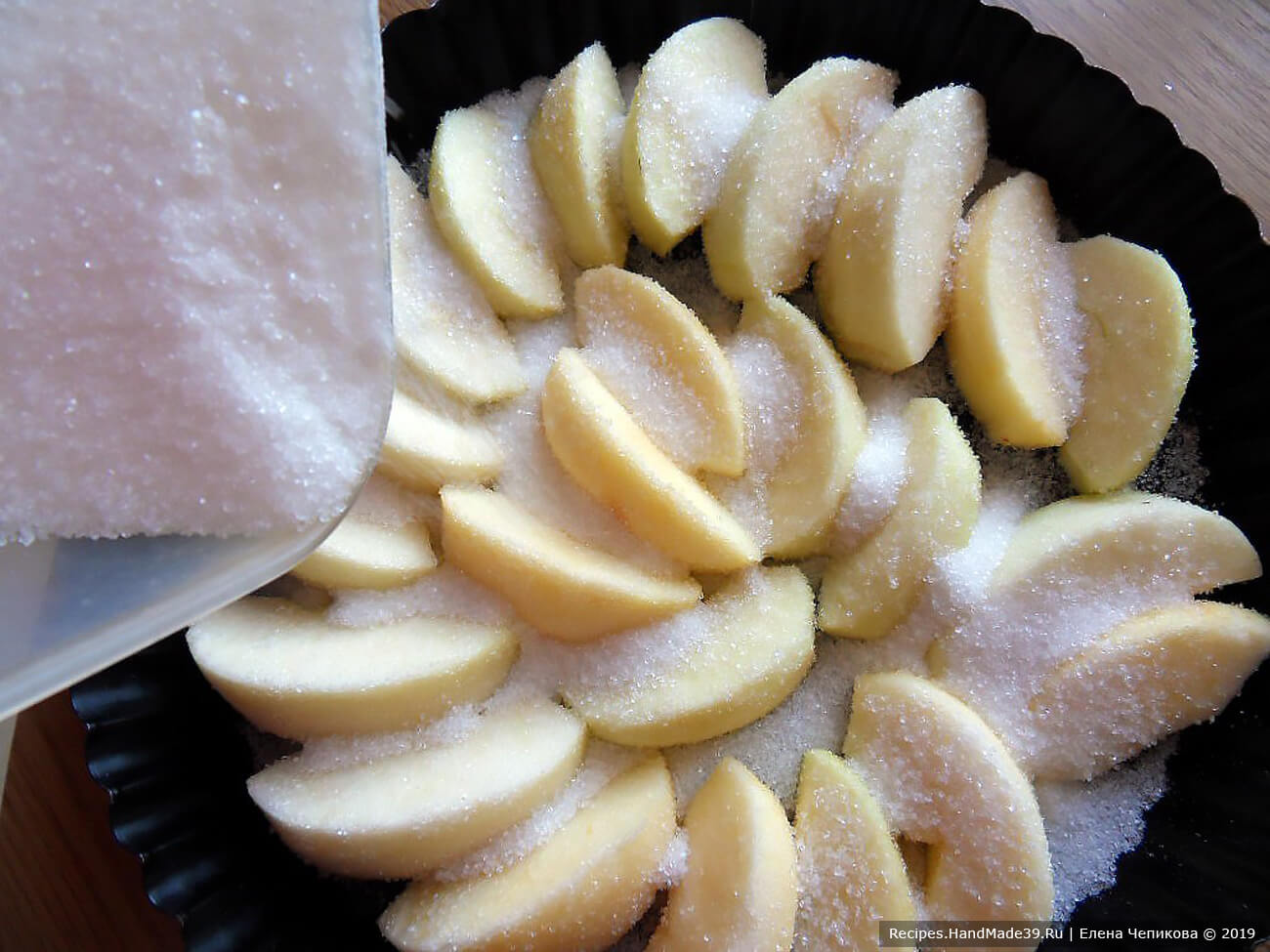 Выложить яблоки в форму для запекания, посыпать 100 г сахара