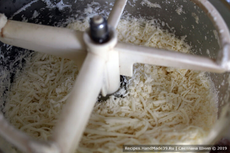 Плавленый сыр измельчить в кухонном комбайне или натереть на тёрке
