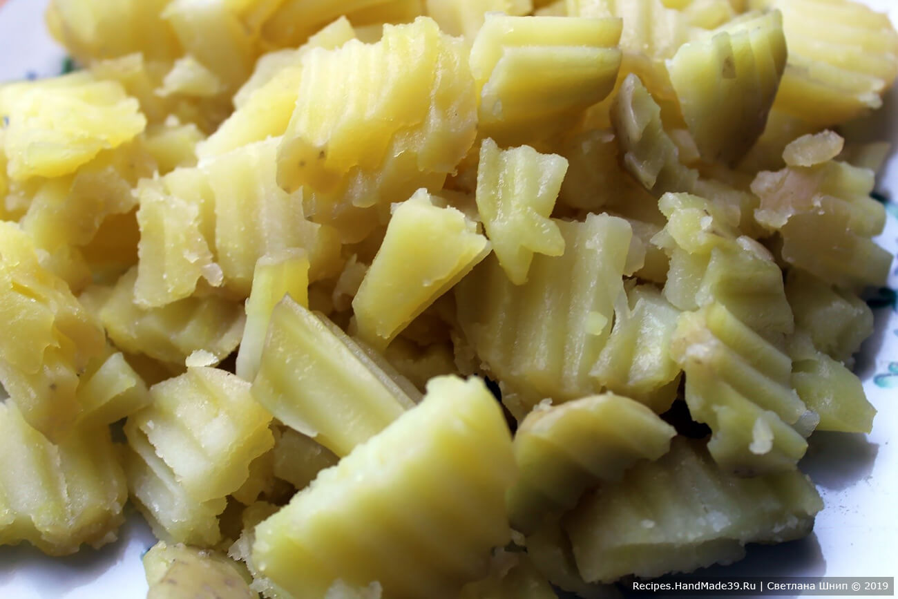 Подготовка ингредиентов для салата: картофель вымыть, отварить в мундире до готовности, остудить, очистить от кожуры. Нарезать брусочками или небольшими пластинами