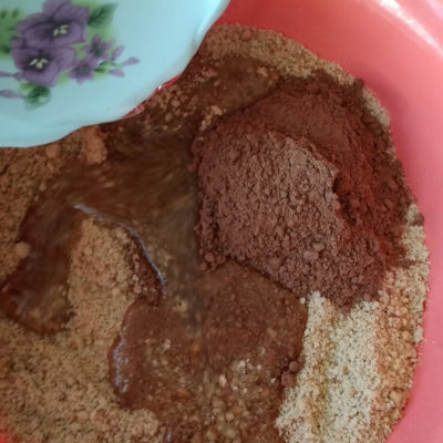 Добавить в измельчённое печенье какао-порошок, сладкую воду (или молоко)