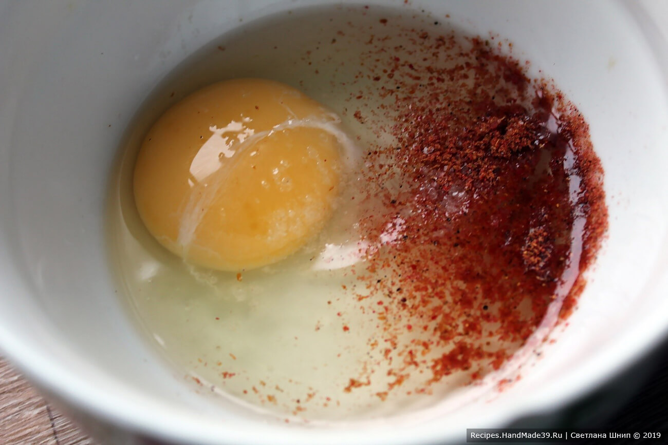 Приготовление блинчиков к супу: в миску разбить куриное яйцо, добавить соль, перец, перемешать