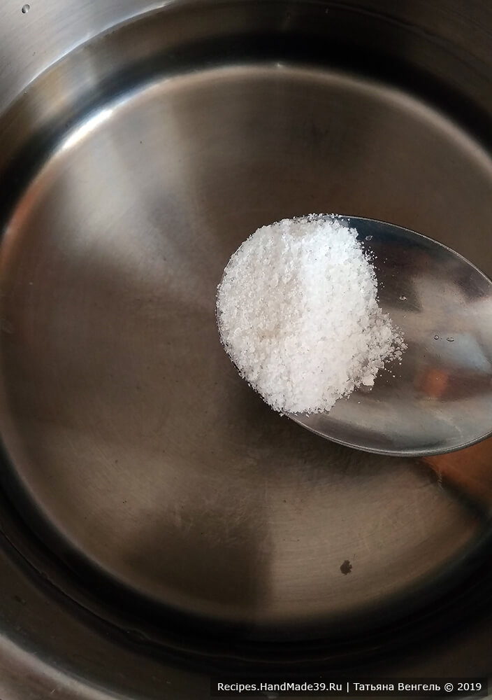 Приготовление заварного теста для пельменей: в кастрюльку влить воду, всыпать соль, довести до закипания на плите