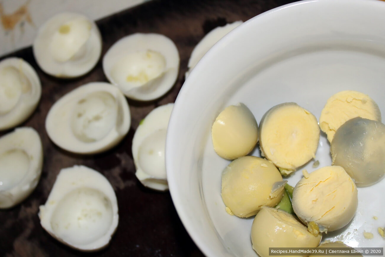 Яйца сварить вкрутую, очистить. Разрезать яйца пополам, желтки извлечь и сложить в отдельную посуду