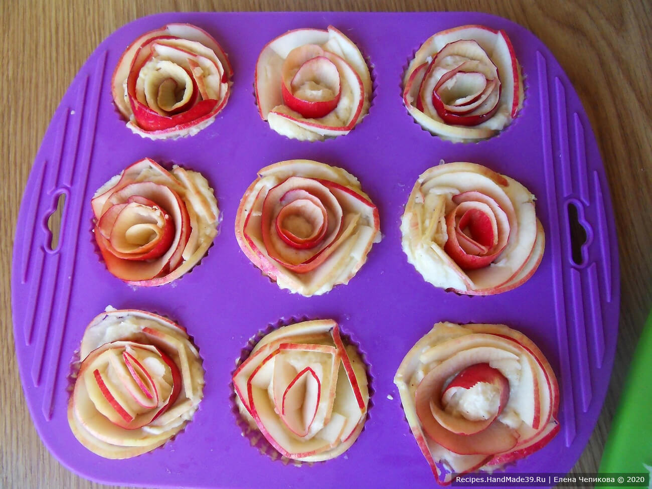 Уложить тонкие дольки яблок в ячейки формы для выпечки кексов по кругу, начиная от бортика, формируя «розу»