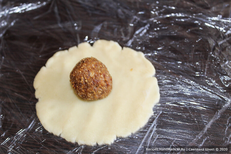 Печенье с инжиром – фото шаг 12. Каждый кусочек теста выложить на пищевую плёнку, разровнять руками до плоской круглой лепёшки. Выложить в центр лепёшки 1 чайную ложку начинки
