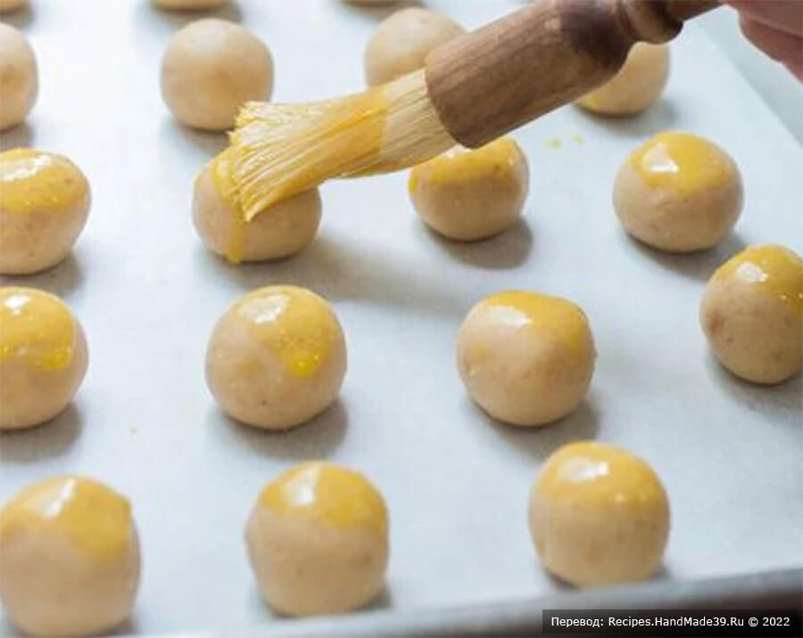 Песочное печенье с арахисом – фото шаг 5. Слегка взбейте яичный желток и смажьте им верхнюю часть каждого печенья
